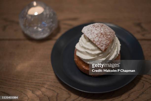 semla (plural semlor) are cream buns, with almond paste, traditionally eaten on, or before, shrove tuesday in sweden / scandinavia. also known as fastlagsbulle, laskiaispulla, vastlakukkel, fastelavnsbolle - shrovetide stockfoto's en -beelden