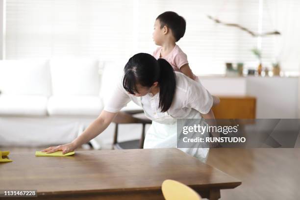 mother carrying baby boy and cleaning table - family housework stock pictures, royalty-free photos & images