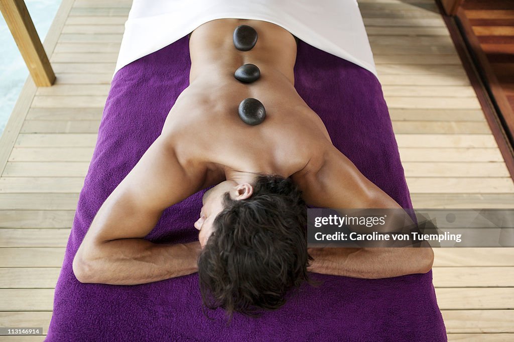 Man having hot stone massage treatment