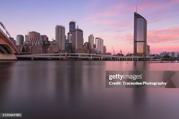 cityscape of brisbane city with pink clouds at sunset from across the brisbane river. - brisbane skyline stock pictures, royalty-free photos & images