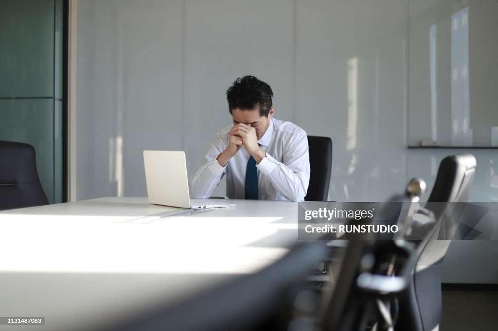 Stressed mature businessman with laptop