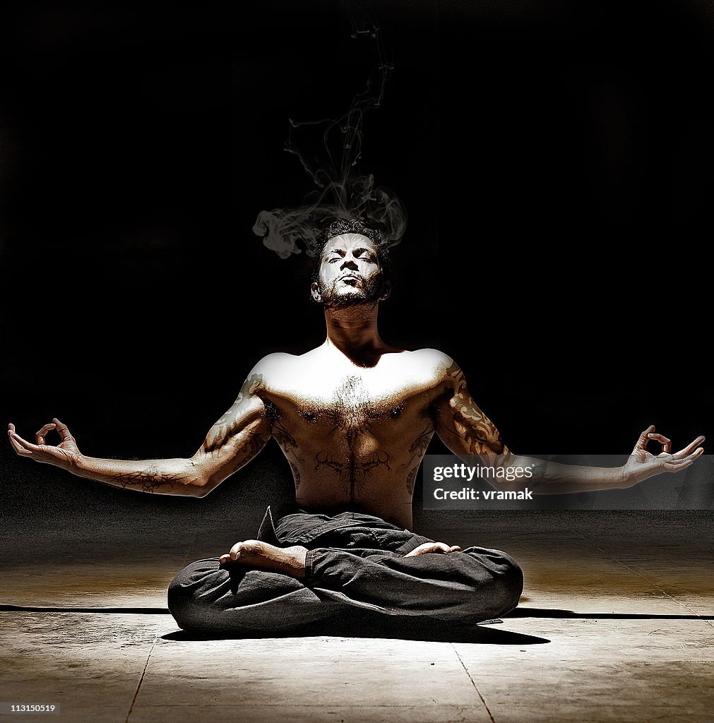 Man with Tattoos Meditating in Yoga Posture