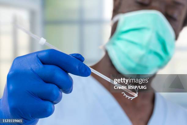 doctor holding a copper iud. - birth control stockfoto's en -beelden