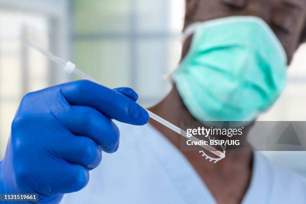 doctor holding a copper iud. - iud stock pictures, royalty-free photos & images