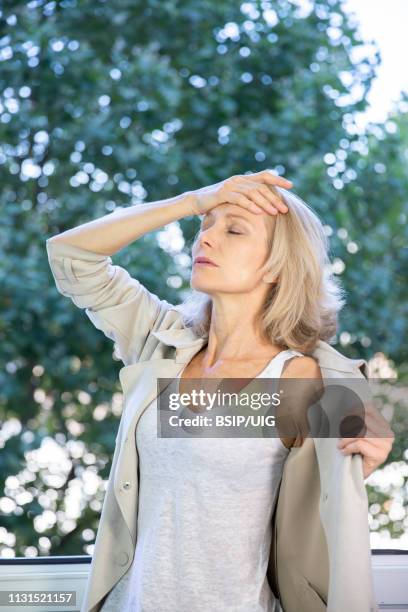 a menopausal woman having a hot flush. - hot flash stock pictures, royalty-free photos & images