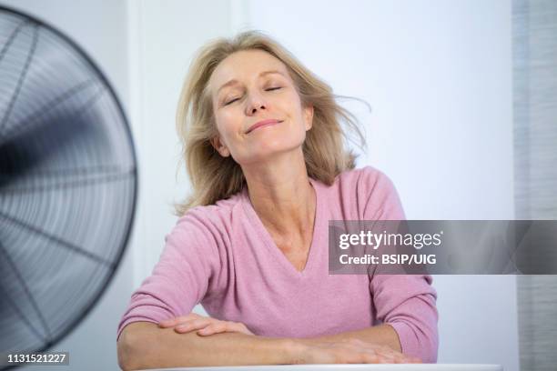 a menopausal woman having a hot flush. - hot flash stock pictures, royalty-free photos & images