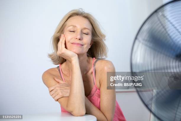 a menopausal woman having a hot flush. - hot flash stock pictures, royalty-free photos & images