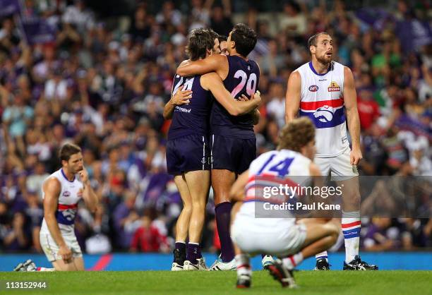 Dylan Roberton, Nick Lower and Matthew Pavlich of the Dockers celebrate winning the game as Callan Ward and Ben Hudson of the Bulldogs look on...