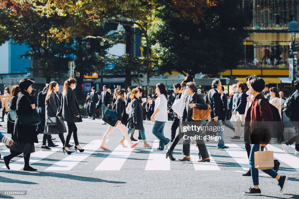 Crowd of busy commuters crossing street in Shibuya crossroad, Tokyo