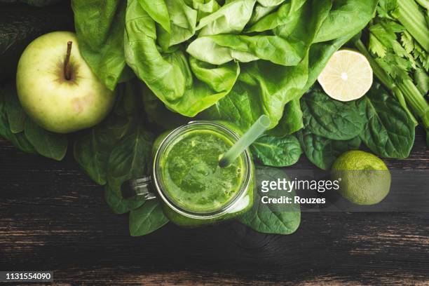 green vegetable juice on wooden background - avocado smoothie stock pictures, royalty-free photos & images
