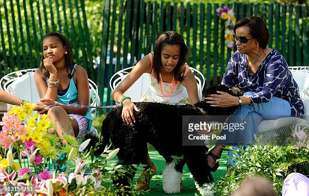 Sasha Obama, Malia Obama and Michelle Obama's mother Marian Robinson play with their dog Bo as President Barack Obama reads to children during the...
