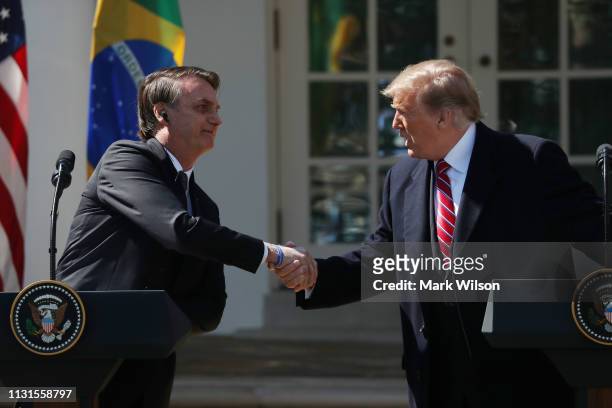 President Donald Trump and Brazilian President Jair Bolsonaro shake hands during a joint news conference at the Rose Garden of the White House March...