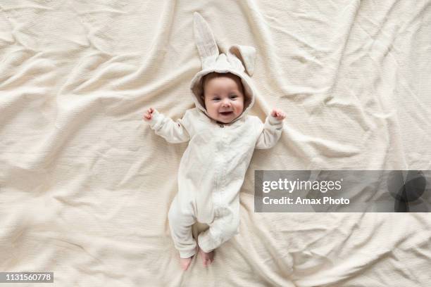 cute little baby in bunny costume on blanket at home, top view - easter rabbit stock pictures, royalty-free photos & images