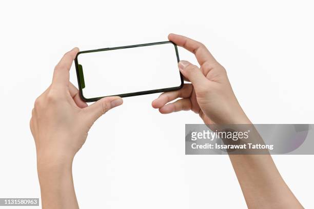 two hands holding big screen smart phone - horizontal stock-fotos und bilder