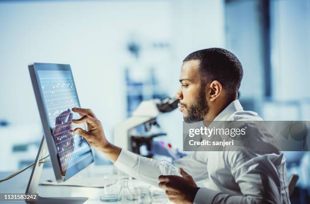 wetenschappers werken in het laboratorium, met behulp van touch screen - patholoog stockfoto's en -beelden