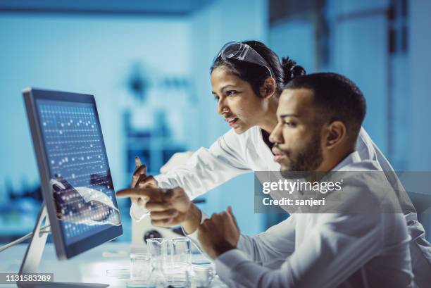 scienziati che lavorano in laboratorio, utilizzando touch screen - research foto e immagini stock