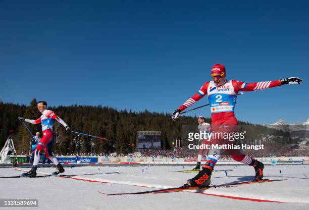 Sjur Roethe of Norway celebrates as he crosses the finish line ahead of Alexander Bolshunov of Russia to win the Cross Country Skiathlon Men 30k race...