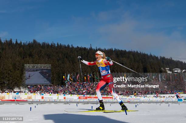 Therese Johaug of Norway celebrates as she crosses the finish line to win the Cross Country Skiathlon Ladies 15k race during FIS Nordic World Ski...