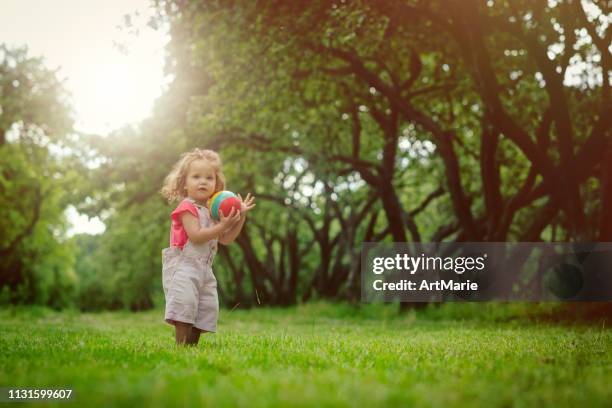 happy little girl with ball in summer outdoors - ballkid stock pictures, royalty-free photos & images