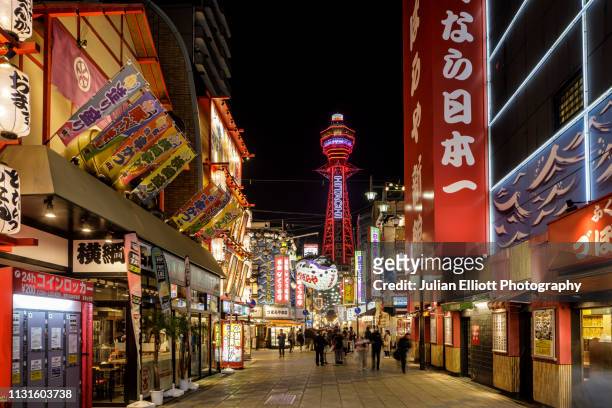 the tsutenkaku at night in osaka, japan. - osaka prefecture stock pictures, royalty-free photos & images