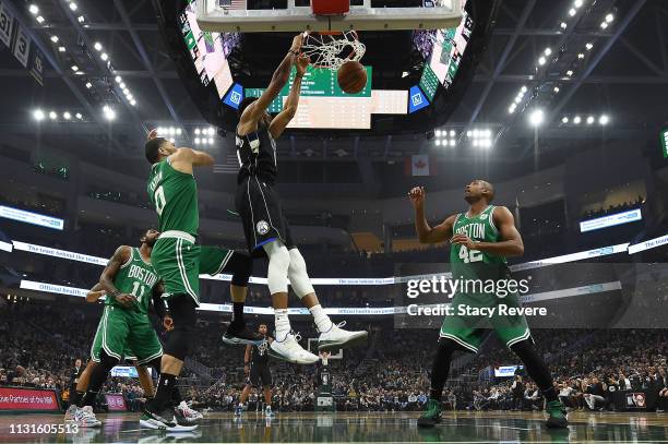 Giannis Antetokounmpo of the Milwaukee Bucks dunks in front of Jayson Tatum of the Boston Celtics during a game at Fiserv Forum on February 21, 2019...