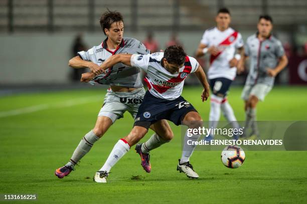 Cristian Bernardi of Argentina's Colon de Santa Fe vies for the ball with Alvaro Ampuero of Peru's Deportivo Municipal during their Sudamericana Cup...