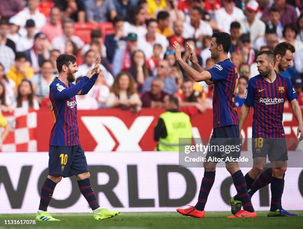 Lionel Messi of FC Barcelona celebrates with his teammates Sergio Busquets of FC Barcelona after scoring his team's third goal during the La Liga...