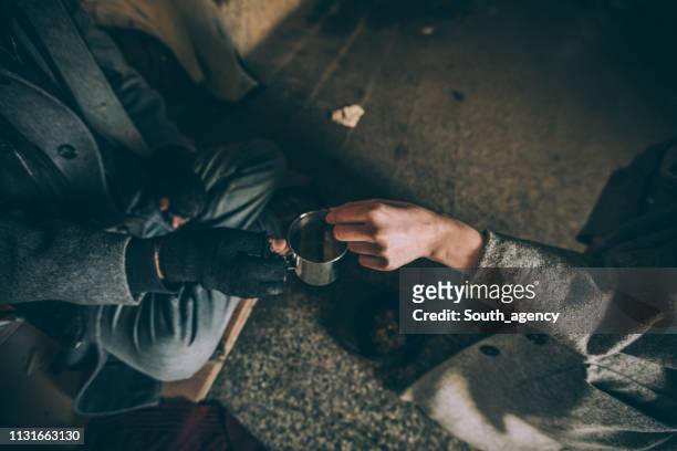 young woman giving money to homeless gay - begging stock pictures, royalty-free photos & images