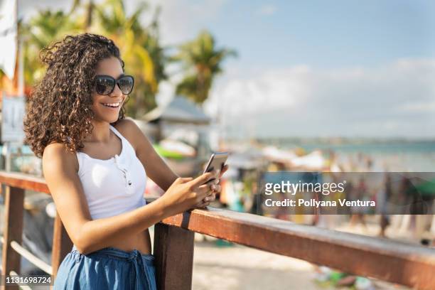 girl using phone in porto de galinhas - hot latino girl stock pictures, royalty-free photos & images
