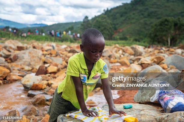 Young girl washes in a stream her donated dress near the Chimanimani Rural Hospital where displaced people following cyclone Idai are sheltered, in...