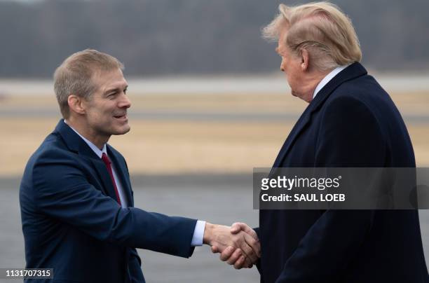 President Donald Trump shakes hands with US Representative Jim Jordan, Republican of Ohio, as he disembarks from Air Force One upon arrival at Lima...
