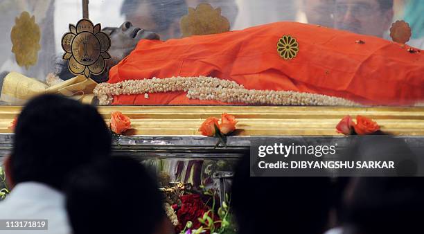 The body of Sathya Sai Baba is displayed in a transparent casket as devotees pay their last respects to the Hindu guru inside Prashanthi Nilayam in...