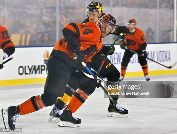 Sean Couturier of the Philadelphia Flyers pushes past Nick Bjugstad of the Pittsburgh Penguins in the third period during the 2019 Coors Light NHL...