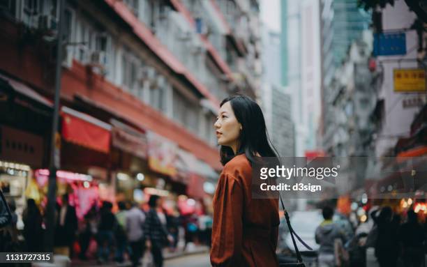young asian woman exploring and strolling in local street market in hong kong - chinese culture stock-fotos und bilder