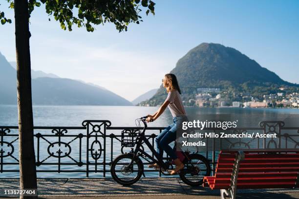 woman enjoys lake promenade with bicycle - lugano switzerland stock pictures, royalty-free photos & images