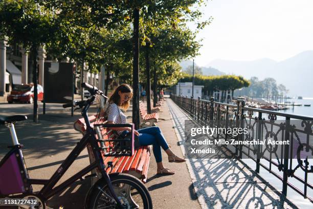 woman enjoys lake promenade with bicycle - lugano switzerland stock pictures, royalty-free photos & images