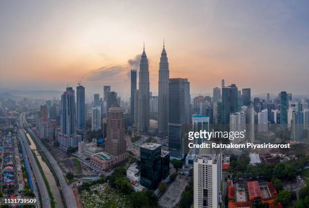 aerial view cityscape of kuala lumpur, malaysia at dawn, with illuminated petronas towers and communication tower in the distance. - kuala lumpur photos et images de collection