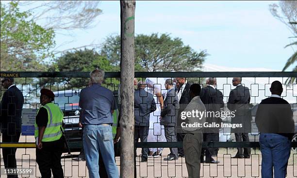 Security personnel surround the bride and her father as they arrive to attend the wedding celebrations for President Jacob Zuma's daughter Duduzile...