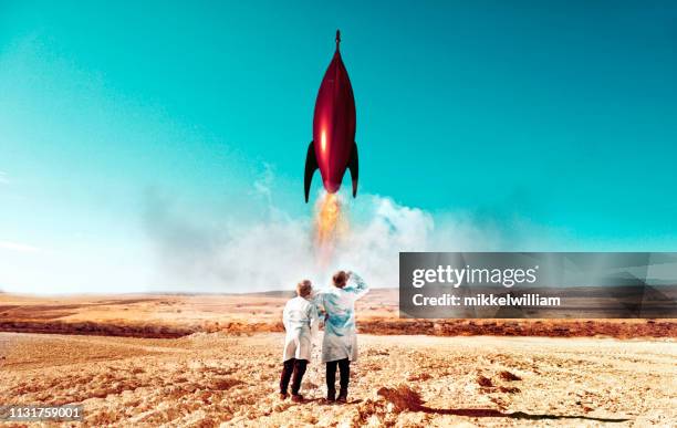 rocket launch in desert carried out by two children wearing labcoats - rocket engine stock pictures, royalty-free photos & images