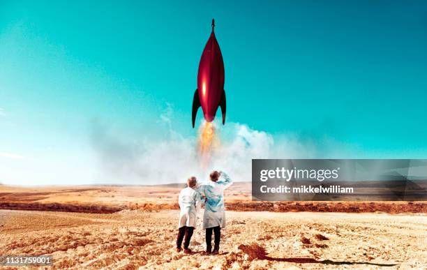 rocket launch in desert carried out by two children wearing labcoats - rocket imagens e fotografias de stock