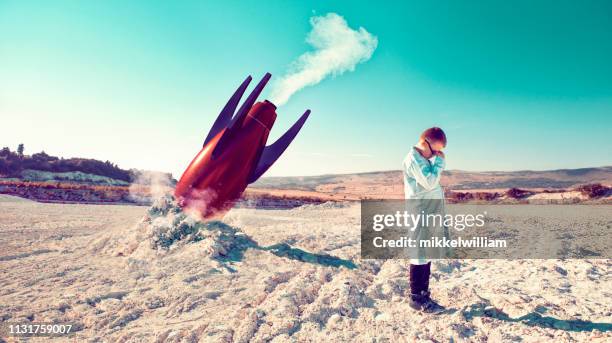 rocket fails and falls to the ground while child in lab coat shows his disbelief - scientific experiment stock pictures, royalty-free photos & images