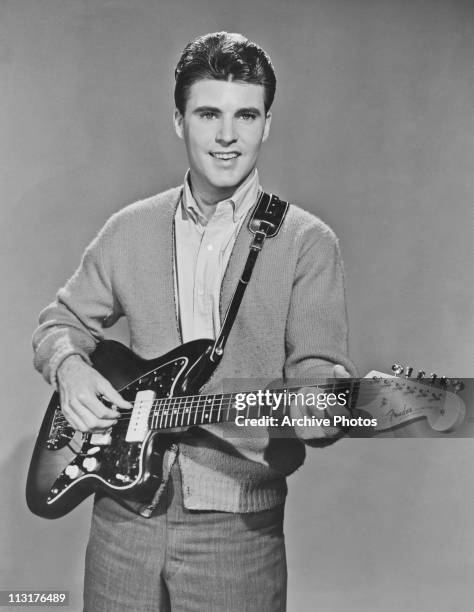 American singer, musician and actor Ricky Nelson poses with a Fender Jazzmaster guitar circa 1958.