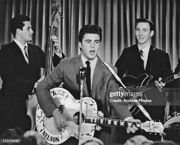 American singer, musician and actor Ricky Nelson performing on stage with bassist James Kirkland and guitarist James Burton circa 1958.