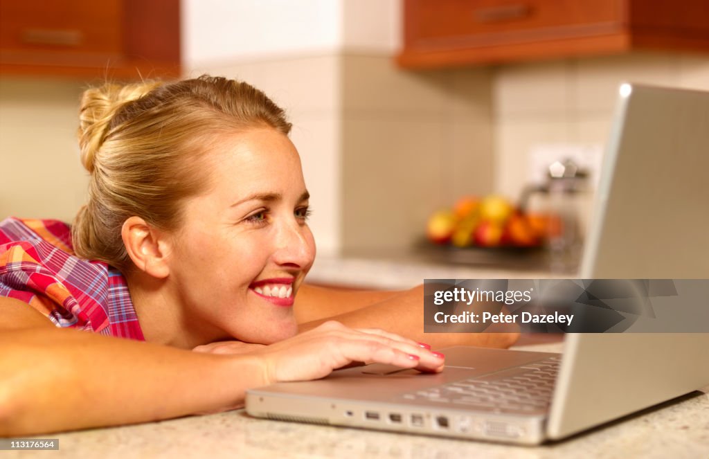 Woman on laptop in kitchen