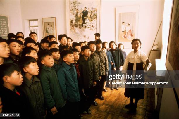 Guide shows a group of schoolchildren round a museum, North Korea, February 1973.