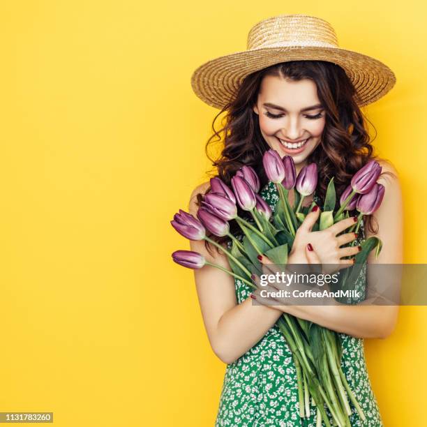 mooie vrouw met paarse tulpen bos - purple hat stockfoto's en -beelden