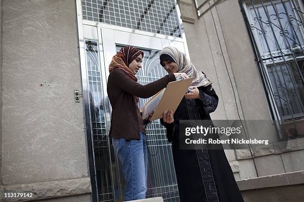 High school senior Asmaa Rimawi, right, checks a Democratic Party voters list during a petition drive for party candidates with her older sister,...