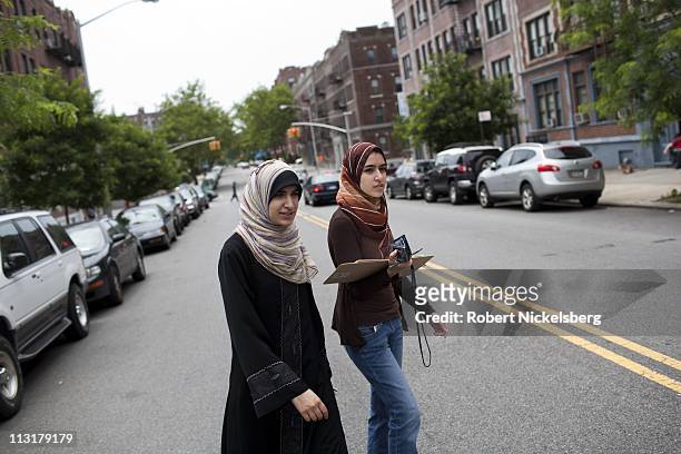 High school senior Asmaa Rimawi, left, crosses a street with her older sister, Fatimah, right, while working with a Democratic Party voters list...