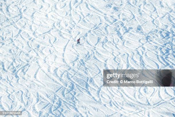 skier off-track skiing on a ski slope - downhill stockfoto's en -beelden