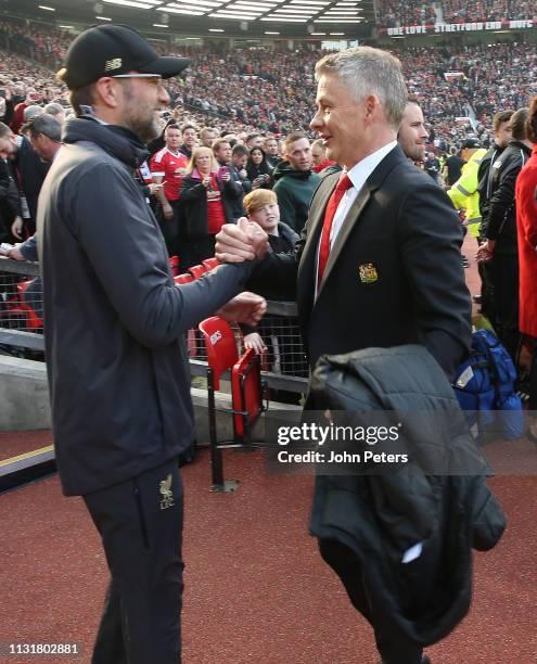 Caretaker Manager Ole Gunnar Solskjaer of Manchester United greets Manager Jurgen Klopp of Liverpool ahead of the Premier League match between...